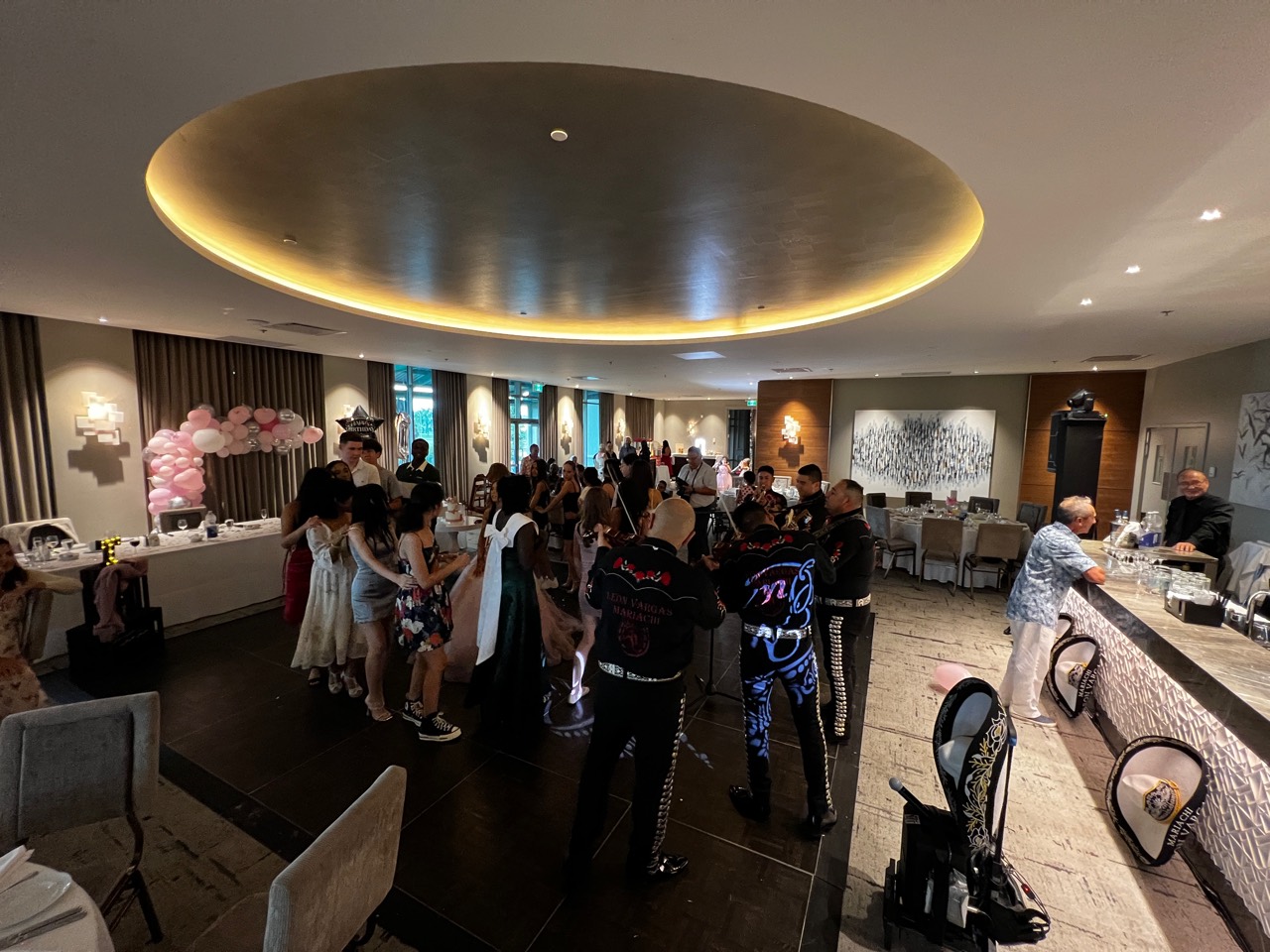 Mariachis entourés des invités sur la piste de danse d’une Quinceañera