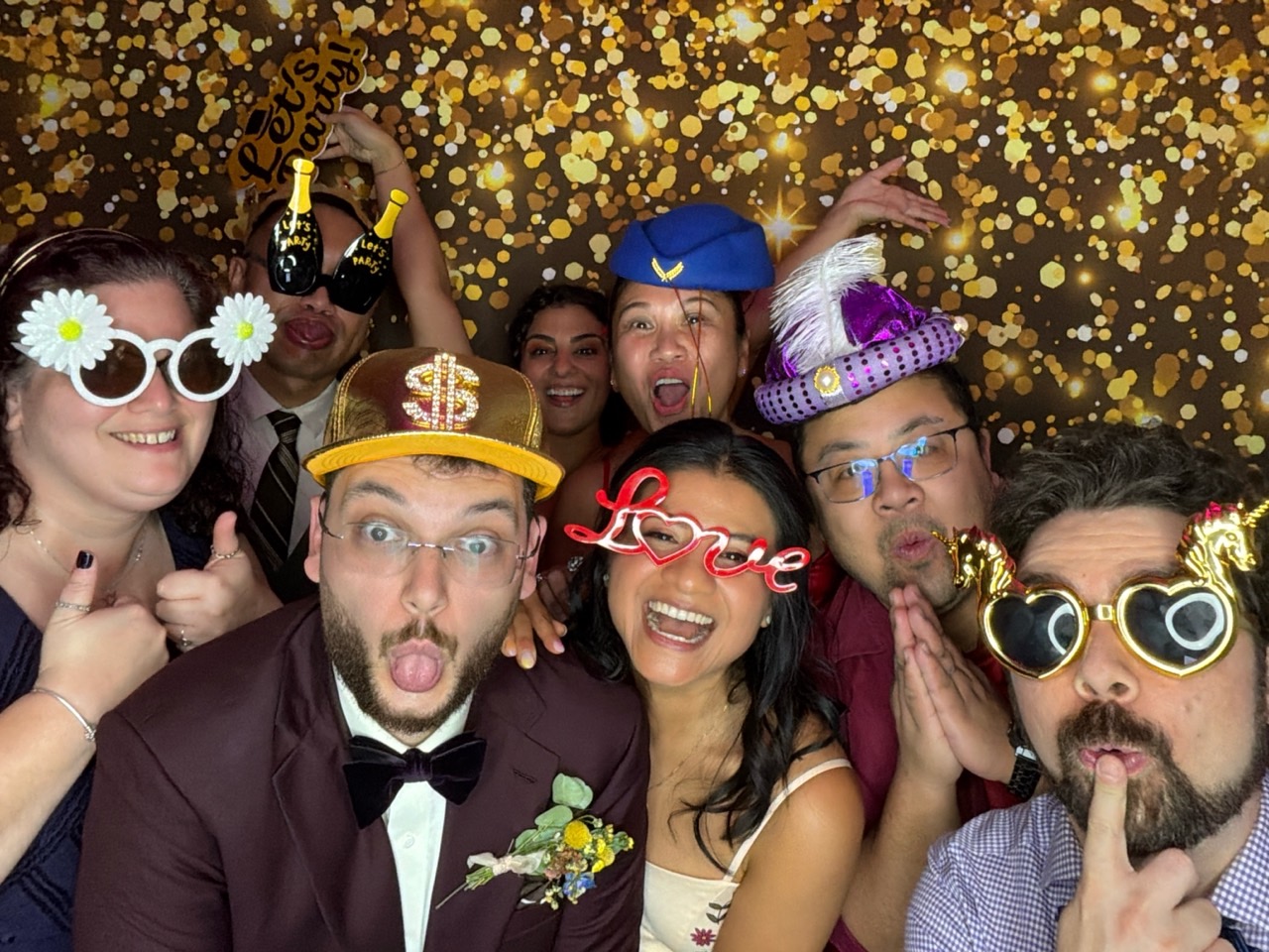 Mariés et invités faisant une pose amusante au photobooth numérique