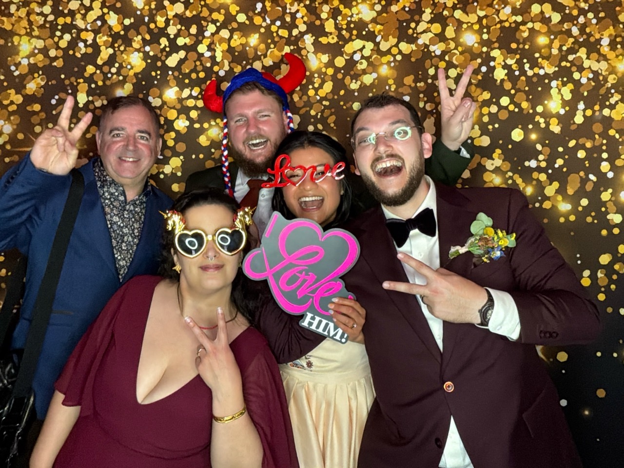 Mariés et amis posant ensemble au photobooth numérique de mariage